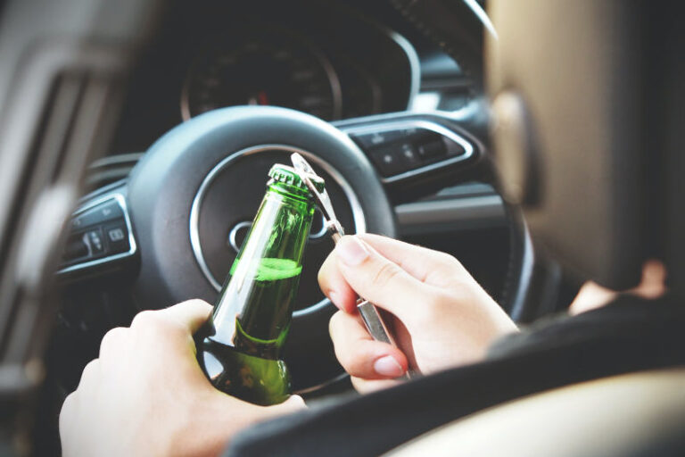 Osoba otwierająca butelkę piwa w samochodzie