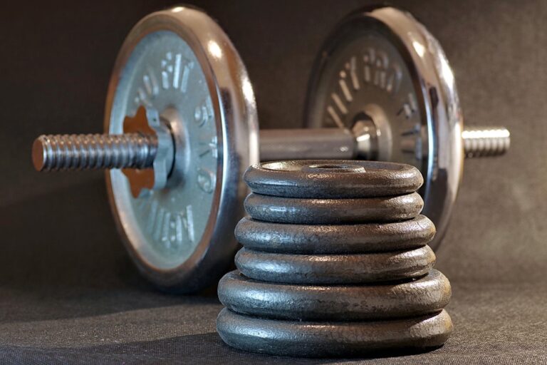 Hantel i zestaw ciężarków na ciemnym tle