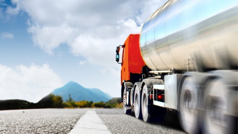 Czerwony ciężarówka na drodze z górami w tle