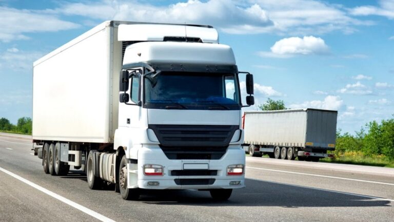 Biały ciężarówka na drodze z niebieskim niebem
