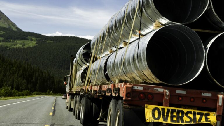 Transport ponadgabarytowy z dużymi rurami na ciężarówce