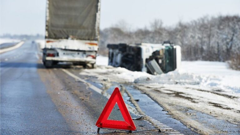 Wypadek drogowy z przewróconym ciężarówką w śniegu
